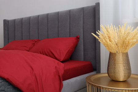 Comfortable bed and decorative plants on table in bedroom. Interior designの写真素材