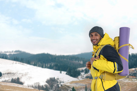 Happy tourist with backpack in snowy mountains