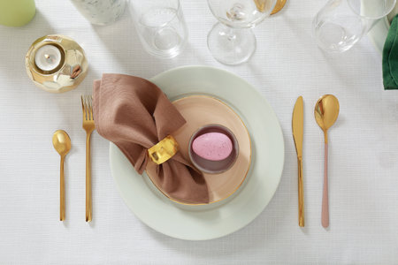 Festive Easter table setting with painted egg and burning candle, flat lay