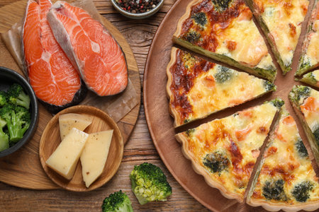 Delicious homemade quiche and ingredients on wooden table, flat layの写真素材