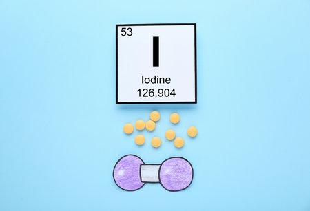 Card with iodine element, atom made of paper and pills on light blue background, flat layの写真素材