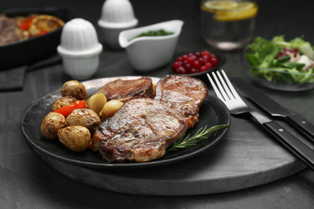 Tasty beef tongue pieces, rosemary and potatoes on gray table, closeupの写真素材
