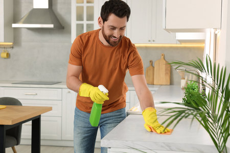 Spring cleaning. Man tidying up kitchen at home