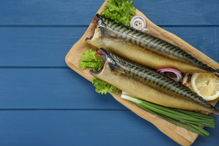 Delicious smoked mackerels and products on blue wooden table, top view. Space for textの写真素材