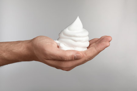 Man holding shaving foam on light gray background, closeupの写真素材