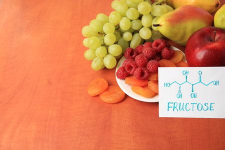 Card with word Fructose, delicious ripe fruits, raspberries and dried apricots on wooden table, space for textの写真素材