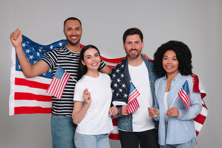 4th of July - Independence Day of USA. Happy friends with American flags on grey backgroundの写真素材