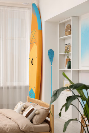 SUP board, bed and furniture in room. Interior designの写真素材