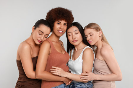 Portrait of beautiful young women on light grey backgroundの写真素材