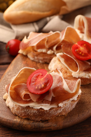 Board of tasty sandwiches with cured ham, tomato and cream cheese on table, closeupの写真素材