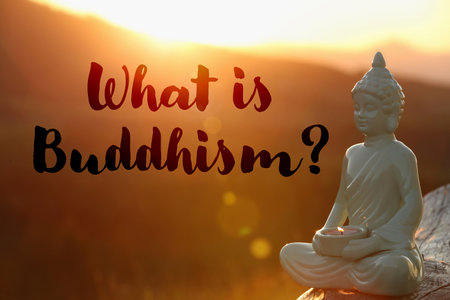 Decorative Buddha statue with burning candle in mountains at sunset and text What Is Buddhism