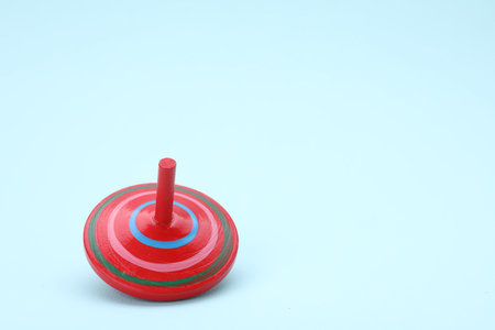 One bright spinning top on light blue background, space for text. Toy whirligigの写真素材