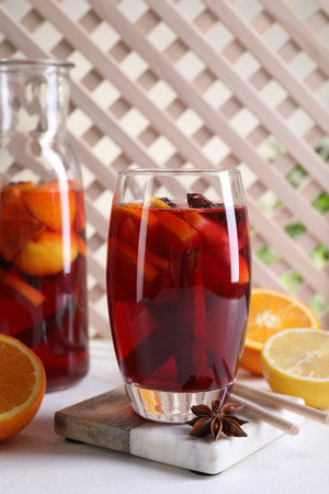 Aromatic punch drink and ingredients on white tableの写真素材