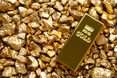 Shiny gold ingot on nuggets, top view. Space for textの写真素材