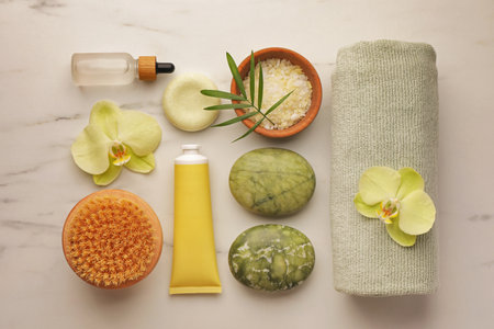 Flat lay composition with spa products and beautiful flowers on white marble tableの写真素材