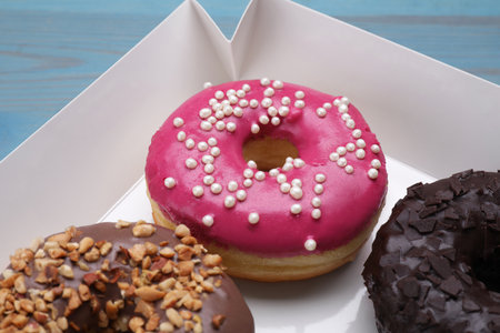 Different tasty glazed donuts in box, closeupの写真素材