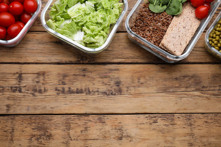 Glass containers with different fresh products on wooden table, flat lay. Space for textの写真素材