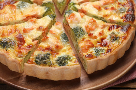 Delicious homemade quiche with salmon and broccoli on wooden board, closeupの写真素材