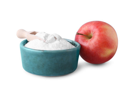 Bowl with sweet fructose powder, scoop and ripe apple on white backgroundの写真素材