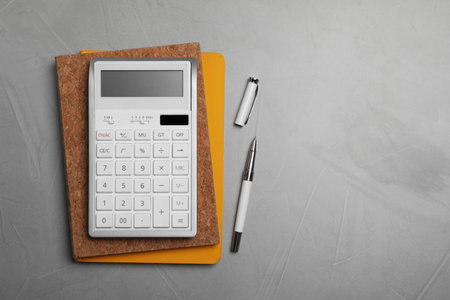 Calculator and office stationery on gray table, top view. Space for textの写真素材