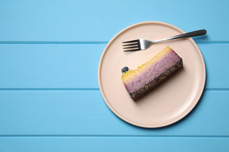 Delicious cheesecake with blueberry on light blue wooden table, top view. Space for textの写真素材