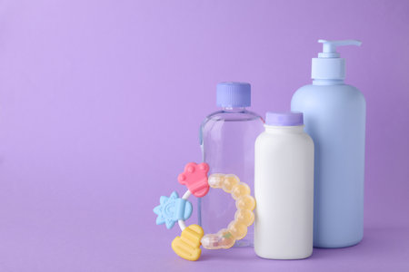 Different skin care products for baby and rattle on violet background, space for textの写真素材