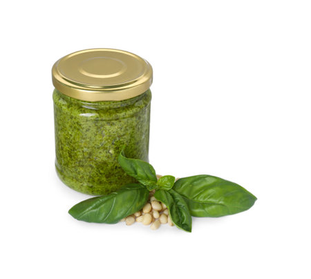 Delicious pesto sauce in jar, pine nuts and basil leaves isolated on whiteの写真素材