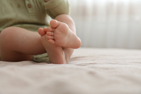 Baby sitting on bed at home, closeup. Space for textの写真素材