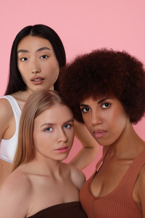 Portrait of beautiful young women on pink backgroundの写真素材