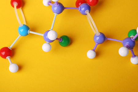Structure of molecule on yellow background, top view. Chemical modelの写真素材