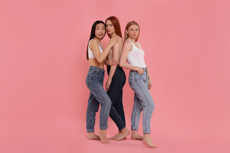 Portrait of beautiful young women on pink backgroundの写真素材