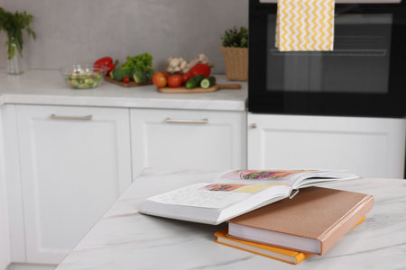 Recipe books on white marble table in kitchen, closeup. Space for textの写真素材