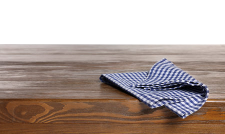 Checkered tablecloth on wooden table against white background