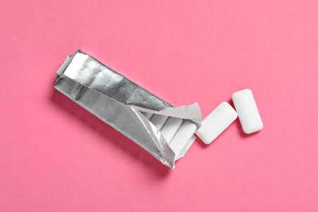 Pack with tasty chewing gums on pink background, flat layの写真素材