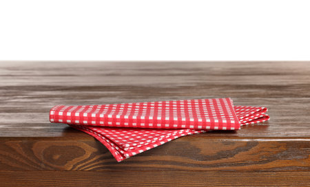 Checkered tablecloth on wooden table against white backgroundの写真素材