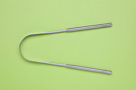 Metal tongue cleaner on light green background, top viewの写真素材