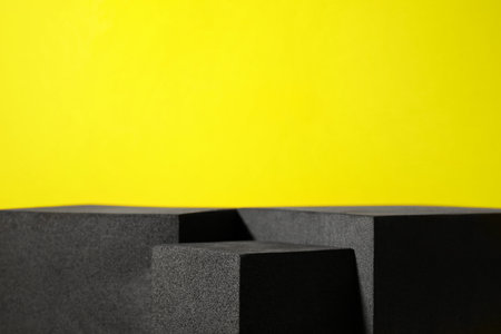 Many black geometric figures on yellow background, closeup with space for text. Stylish presentation for productの写真素材