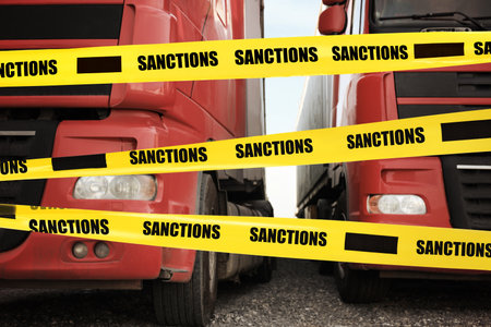 Economic sanctions. Trucks on road in front of barrier tapeの写真素材