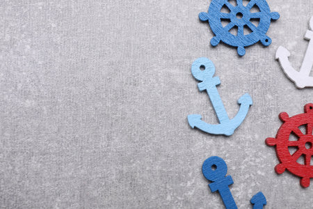 Anchor and ship wheel figures on light gray table, flat lay. Space for textの写真素材