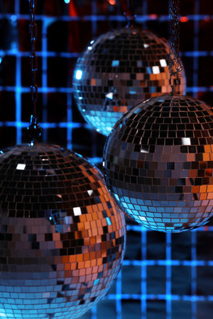 Shiny disco balls against foil party curtain under color lightsの写真素材