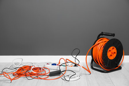 Extension cord reel plugged into power strip indoors, space for text. Electrician's equipmentの写真素材