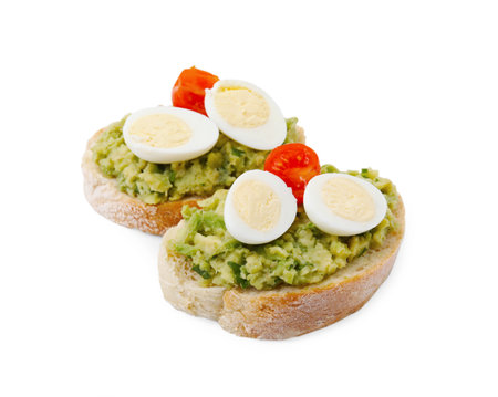 Delicious sandwiches with guacamole, eggs and tomatoes on white backgroundの写真素材