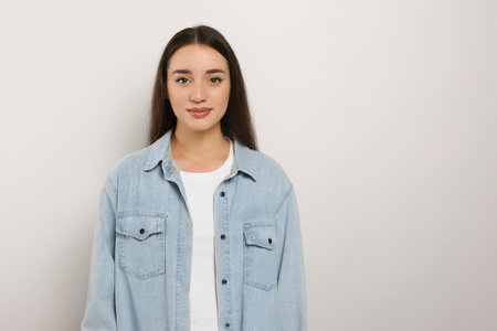 Portrait of beautiful young woman in jeans jacket on white background. Space for textの写真素材