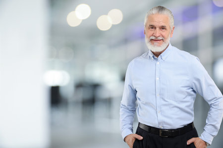 Portrait of handsome senior man in office, space for text
