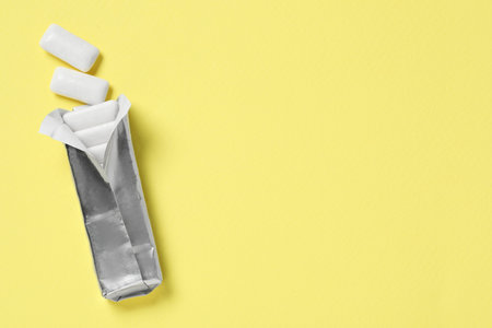 Pack of tasty chewing gums on yellow background, top view. Space for textの写真素材
