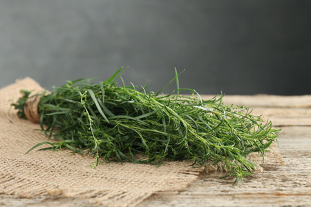Bunch of fresh tarragon sprigs on wooden tableの写真素材