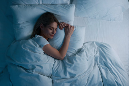 Woman sleeping in bed at night, above view. Space for textの写真素材
