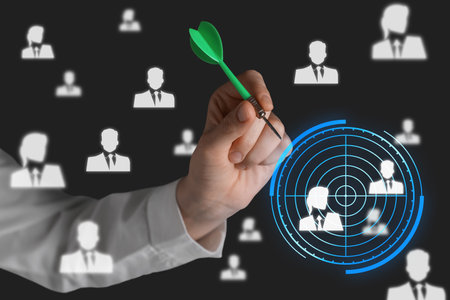 Executive search (headhunting). Woman aiming with dart to digital human icons on dark background, closeupの写真素材