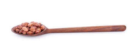 Wooden spoon with dry kidney beans isolated on whiteの写真素材