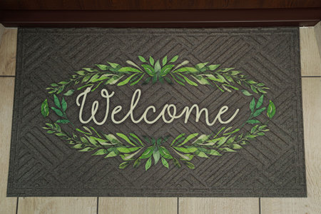 Beautiful doormat with the word Welcome on floor near entrance, top viewの写真素材